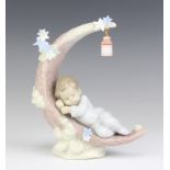A Lladro figure of a child sleeping on a half moon beneath a hanging lamp 6479 16cm