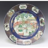 An 18th Century Chinese famille verte plate decorated with figures on a pavillion terrace enclosed