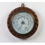 An Edwardian aneroid barometer with porcelain dial contained in a carved oak case with rope edge