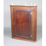 A Georgian mahogany hanging corner cabinet with moulded cornice, the interior fitted shelves