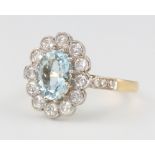 An 18ct yellow gold oval aquamarine and diamond cluster ring, centre stone 1.8ct, surrounded by