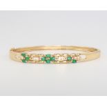 A 14ct yellow gold emerald and diamond bangle, 14 grams