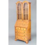 A Queen Anne style figured walnut bureau bookcase, the double domed top fitted shelves enclosed by