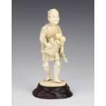 A Japanese Meiji period carved ivory figure of a standing gardener with basket 18cm The head and arm