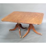 A 19th Century mahogany twin pillar extending dining table with 2 extra leaves raised on a turned