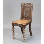 A Victorian carved oak hall chair with solid seat and back, raised on bobbin turned supports