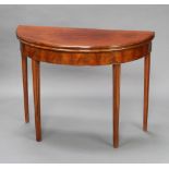 A Georgian mahogany demi-lune card table raised on square tapered supports 73cm h x 96cm w x 45cm