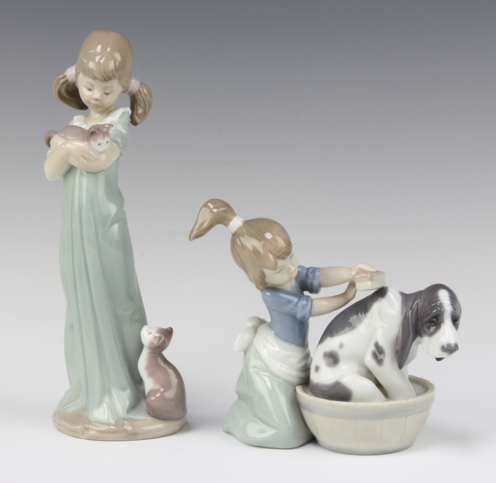 A Lladro figure of a kneeling girl scrubbing a hound dog, base marked 5455 11cm, ditto girl with
