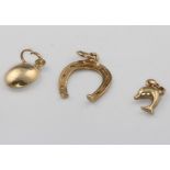 A 9ct yellow gold horseshoe charm, a dolphin charm, coffee bean charm 1.2 grams