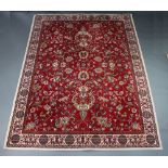 A red and white floral patterned Persian style machine made carpet 339cm x 251cm Some light