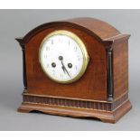 An Edwardian striking mantel clock with enamelled dial and Arabic numerals contained in an arched