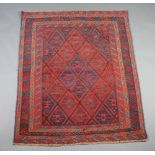 A red and blue ground Gazak rug with all-over diamond design to the centre within a multi row border
