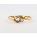 An 18ct yellow gold cross-over 3 stone diamond ring size K 1/2, 2.5 grams