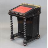 A Victorian ebonised Davenport desk, the upper section with pierced brass gallery, the interior