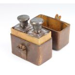A matched pair of silver mounted toilet bottles contained in a fitted leather case London 1908 and