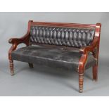 A Victorian mahogany settle, the seat and back upholstered in black rexine, raised on turned