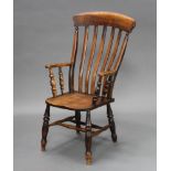 A Victorian beech Windsor stick and rail back kitchen chair with solid seat, raised on turned