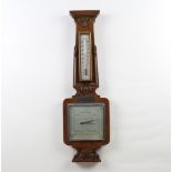 A Shortland 1950's aneroid barometer and thermometer with silvered dial contained in a carved walnut
