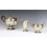 A silver 3 piece tea set with beaded decoration and fancy scroll handles, Sheffield 1922 and 1924,