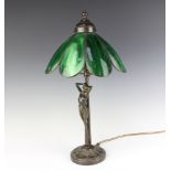 An Art Nouveau style bronzed table lamp supported by a nude lady and with green petal shaped shade