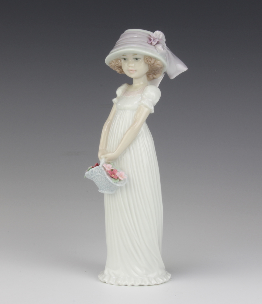 A Lladro figure, standing bonneted girl carrying basket of flowers, the base marked 2004 events