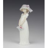 A Lladro figure, standing bonneted girl carrying basket of flowers, the base marked 2004 events