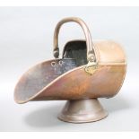 A Victorian copper helmet shaped coal scuttle