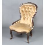 A Victorian ebonised mahogany show frame nursing chair upholstered in mushroom buttoned material,
