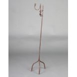 An 18th Century wrought iron adjustable rush light burner 99cm h, raised on 3 supports