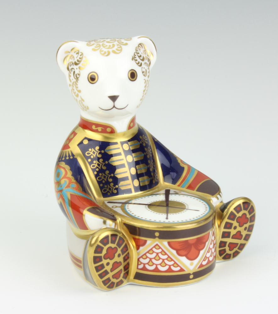 A Royal Crown Derby paperweight in the form of a teddy bear drummer with interlaced double M