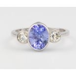 A platinum tanzanite and diamond ring, the centre oval stone 2ct, flanked by 2 brilliant cut