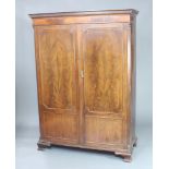 Waring and Gillows, a 19th Century mahogany wardrobe with moulded and dentil cornice, enclosed by