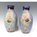 A pair of Continental Art Nouveau blue and floral glazed jugs 41cm One jug has a crack to the base