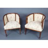 A pair of Edwardian inlaid mahogany tub back chairs upholstered in tapestry material, raised on