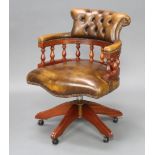 A Victorian style mahogany swivel tub back office chair upholstered in brown buttoned back leather