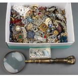 A large magnifying glass together with a quantity of vintage costume jewellery