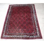 A red and blue ground Persian carpet with all over geometric design within a multi row border