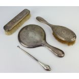 A hammered pattern silver hand mirror Chester 1917, a similar hairbrush, clothes brush and button