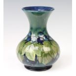 A Moorcroft baluster vase decorated with grapes and leaf design with impressed and signature marks