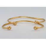 A pair of high carat yellow gold torque bangles, 14 grams