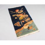 A 1930's blue ground Chinese rug decorated a river, ducks and plants 121cm x 64cm Slight burn