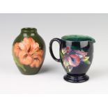A William Moorcroft blue ground jug decorated with the orchid design, base with impressed