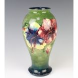 A Walter Moorcroft oviform vase, the graduated green ground decorated with the Hibiscus design,