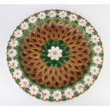 A Victorian Minton Majolica shallow dish decorated with formal flowers and basket weave interior,