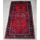 A red and blue ground Afghan rug the central medallion within a multi row border 292cm x 155cm