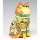 A Rye Pottery cat by Joan and David De Bethel with glass eyes and decoupage decoration, in