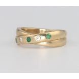 A 9ct yellow gold emerald and diamond crossover ring, 4.1 grams, size J 1/2