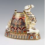 A Royal Crown Derby Imari pattern paperweight of a reclining camel with silver stopper 16cm