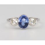 A platinum 3 stone sapphire and diamond ring, the centre oval sapphire 1.85ct flanked by brilliant
