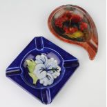 A Moorcroft ashtray the blue ground decorated with a Hibiscus 11cm, a scroll shaped ditto
